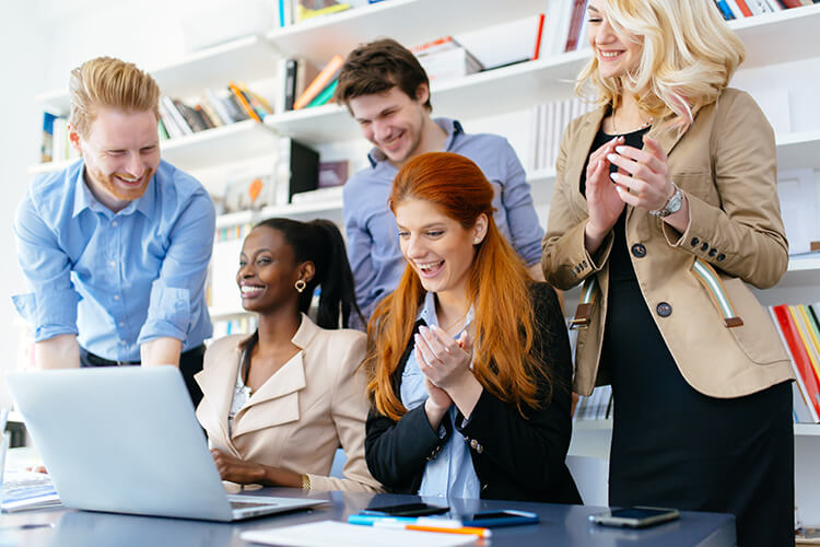 photograph of young professionals at work happy or excited about something happening on the laptop