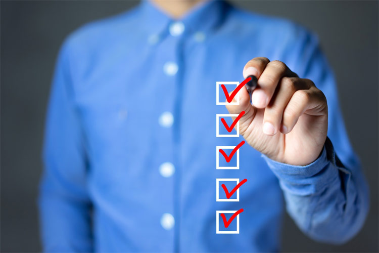 person in blue shirt, drawing five check marks