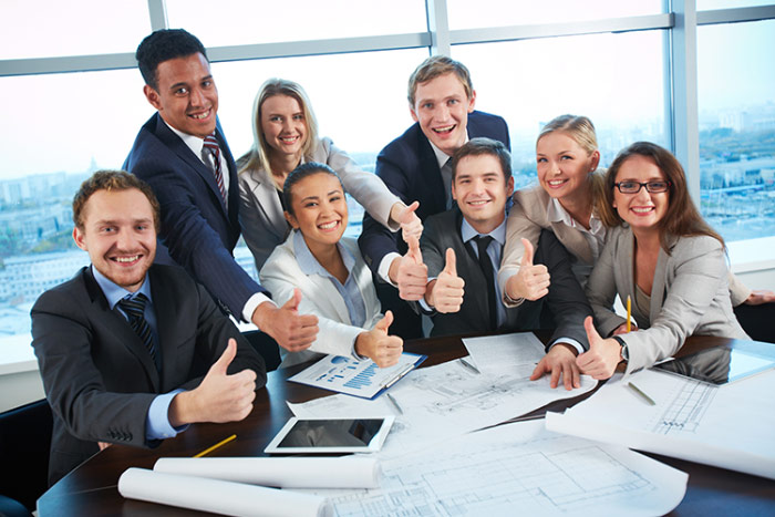 photograph of business profressionals in a meeting, giving thumbs up